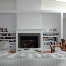 Living room remodel with fireplace, built-in media storage and bookcases, and architectural details