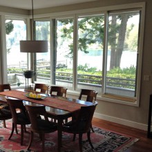 . Custom windows and French doors surround dining room overlooking Sun Day Cove, Bainbridge Island