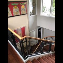Custom metal bannister in stairwell designed to showcase art